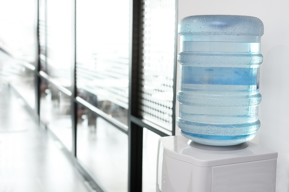 A water dispenser in the hallway of an office.