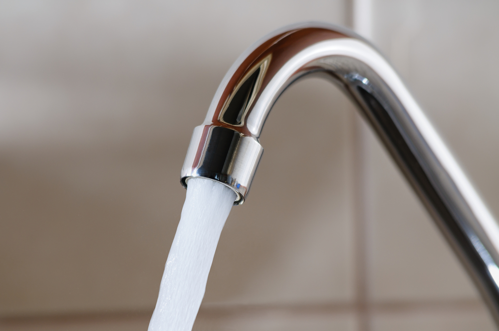 A closeup of a water faucet with high water pressure.